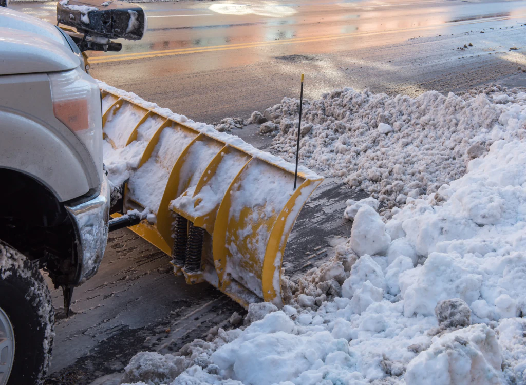 pickup truck with plow removing snow